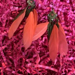 Brass earrings with orange Feathers on it